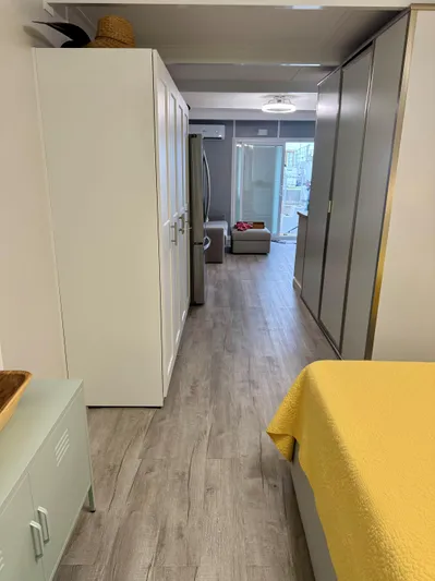  Yacht Photos Pics Modern apartment interior with wooden flooring, yellow bedding, and sleek storage units, 2023 design.