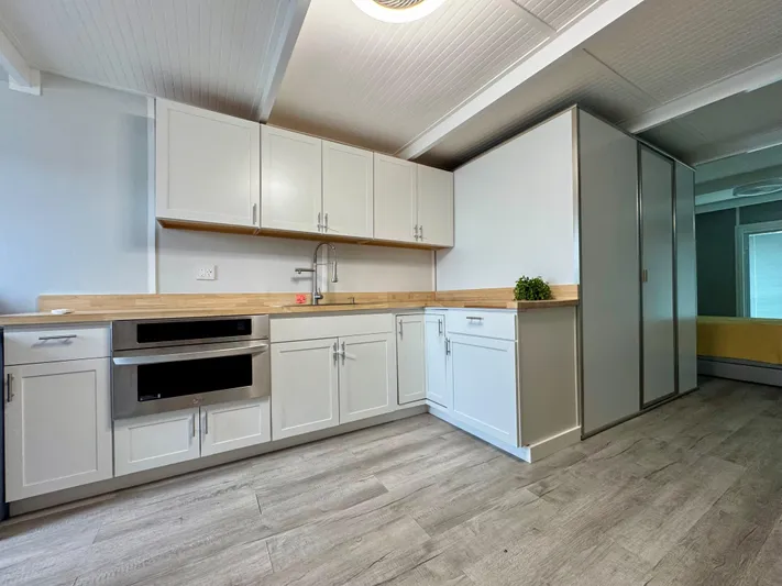  Yacht Photos Pics Modern kitchen with white cabinets, wood countertops, and sleek flooring in a 2023 Modern Struktures MS 400.