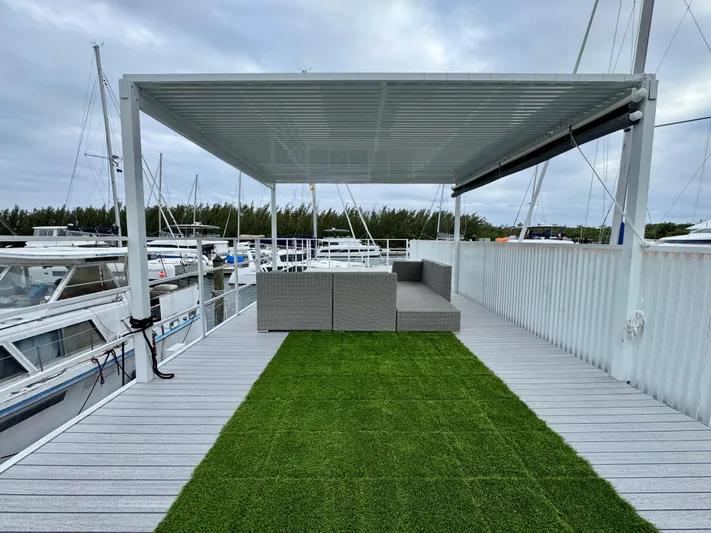  Yacht Photos Pics Modern Struktures MS 400 patio with pergola, artificial grass, and outdoor seating by marina.