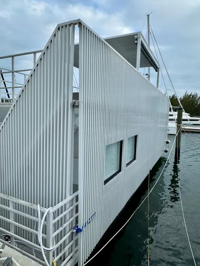  Yacht Photos Pics Modern Struktures MS 400 houseboat, 2023 model, docked with sleek, corrugated exterior design.