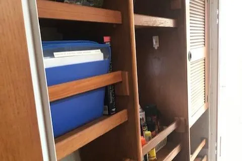 S/v Vr Yacht Photos Pics Wooden storage shelves inside a 2005 Manta 42 MK II boat, holding various items.