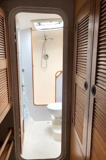 S/v Vr Yacht Photos Pics 2005 Manta 42 MK II yacht bathroom with shower, toilet, and wooden cabinets.
