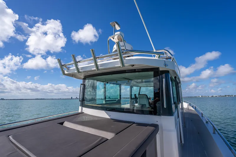  Yacht Photos Pics 2017 Axopar 37 XC Cross Cabin boat on calm water under blue sky.