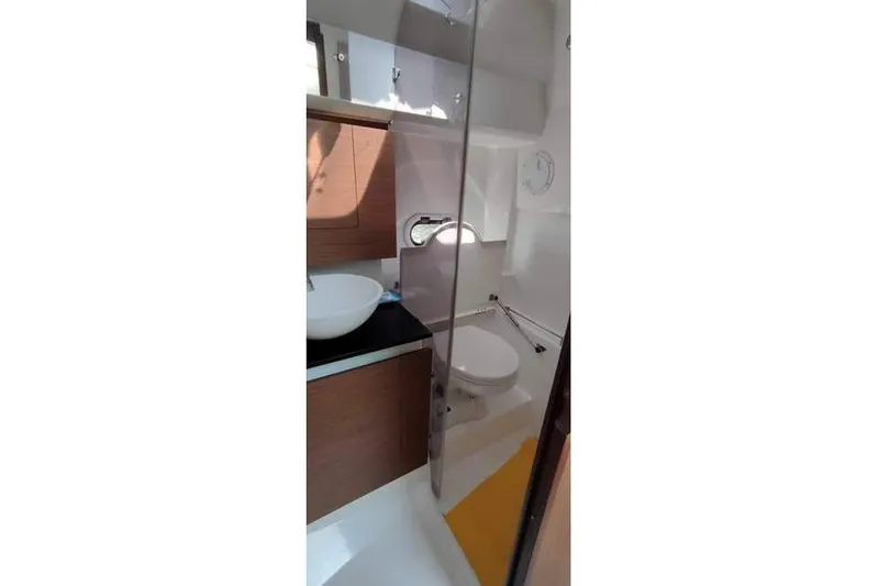  Yacht Photos Pics 2019 Jeanneau Cap Camarat 10.5 WA bathroom with modern fixtures and wooden cabinetry.
