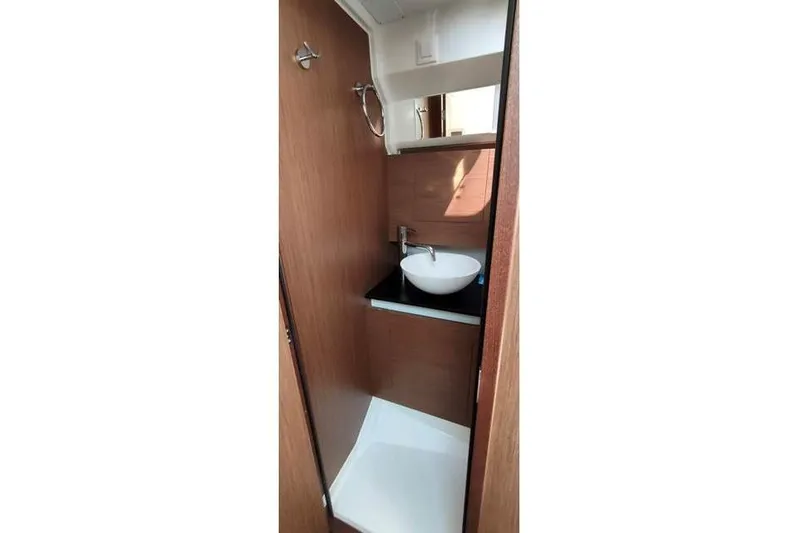  Yacht Photos Pics Compact bathroom in 2019 Jeanneau Cap Camarat 10.5 WA boat, featuring modern sink and wood finish.