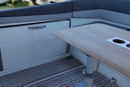  Yacht Photos Pics 2019 Jeanneau Cap Camarat 10.5 WA boat interior with wooden table and seating area.