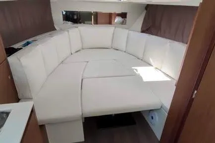  Yacht Photos Pics 2019 Jeanneau Cap Camarat 10.5 WA interior with white cushioned seating area.