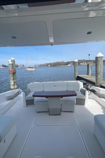  Yacht Photos Pics 2020 Tiara Yachts 53 Coupe, spacious deck with seating, docked by serene waters.