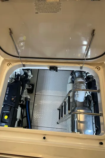 Yacht Photos Pics Engine compartment of 2020 Tiara Yachts C53 Coupe, showcasing mechanical components and ladder.