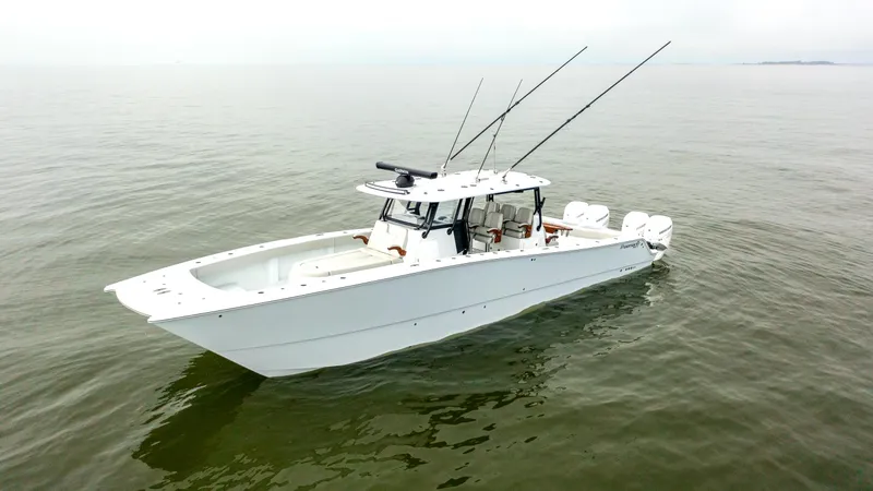  Yacht Photos Pics 2023 Freeman 42 LR boat on calm water, featuring sleek design and multiple fishing rods.