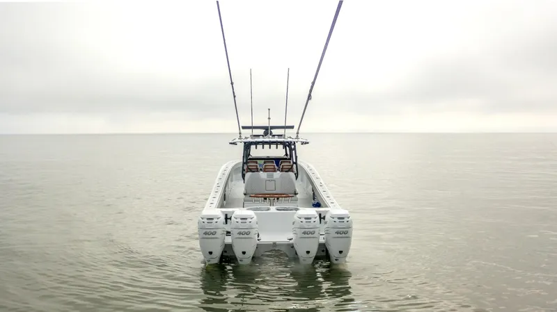 Yacht Photos Pics 2023 Freeman 42 LR boat with four engines on calm water, viewed from the rear.