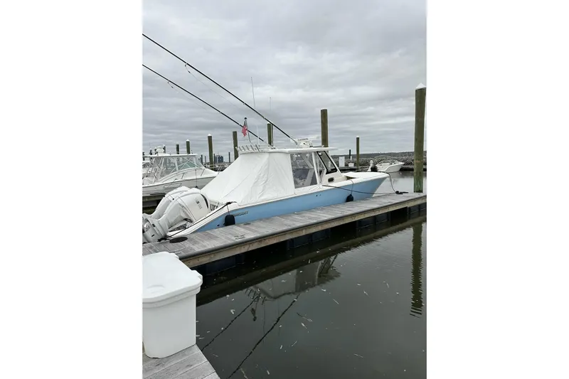 Yacht Photos Pics 2024 Pursuit S 328 Sport boat docked at marina under cloudy sky.