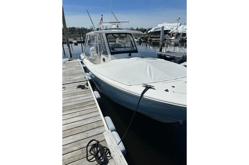  Yacht Photos Pics 2024 Pursuit S 328 Sport boat docked at marina, covered and ready for adventure.
