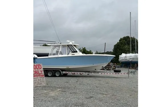  Yacht Photos Pics 2024 Pursuit S 328 Sport boat on trailer in a gravel lot.