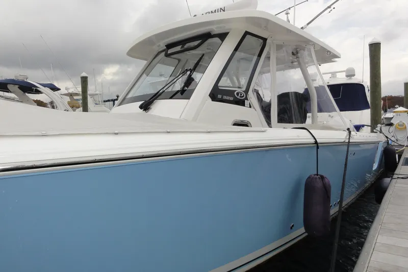  Yacht Photos Pics 2024 Pursuit S 328 Sport boat docked, featuring sleek blue and white design.