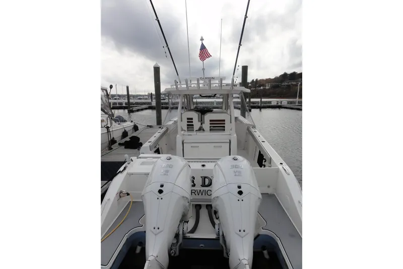  Yacht Photos Pics 2024 Pursuit S 328 Sport boat docked with dual engines and American flag.