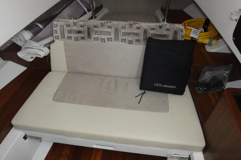  Yacht Photos Pics 2024 Pursuit S 328 Sport cabin interior with cushioned seating and storage.