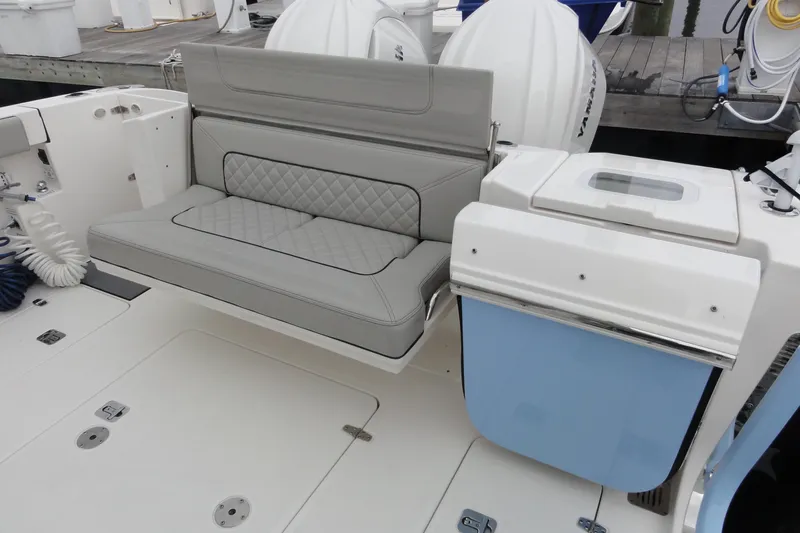  Yacht Photos Pics 2024 Pursuit S 328 Sport boat with gray cushioned seating and storage compartments.