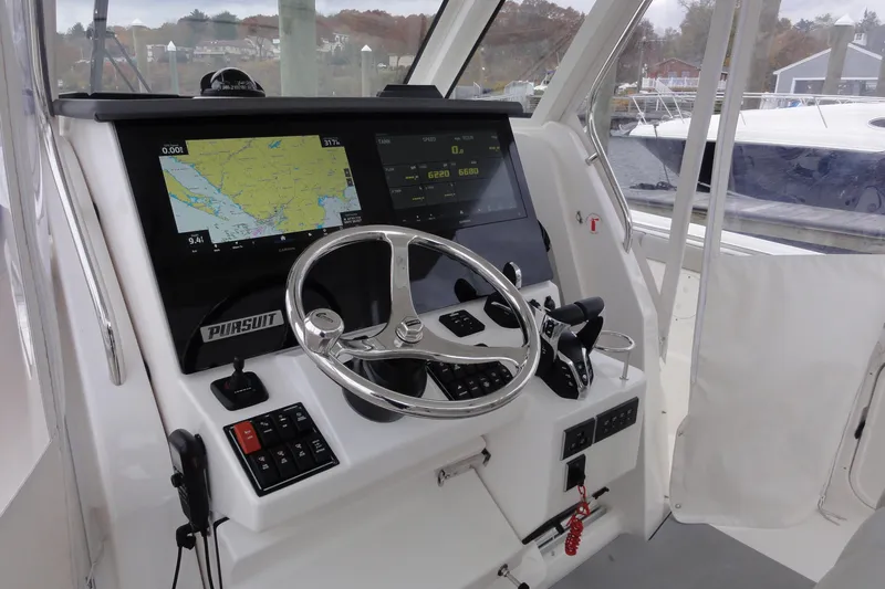  Yacht Photos Pics 2024 Pursuit S 328 Sport boat dashboard with navigation screens and steering wheel.