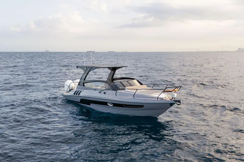  Yacht Photos Pics A sleek 2026 Hanover 305 boat cruising on open water under a cloudy sky.