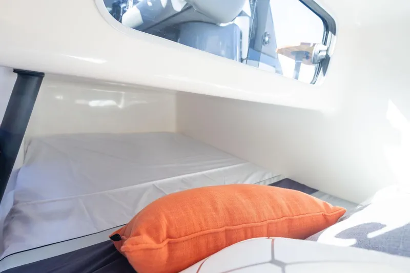 Yacht Photos Pics Cozy interior of 2026 Hanover 305 boat with orange pillow and window view.