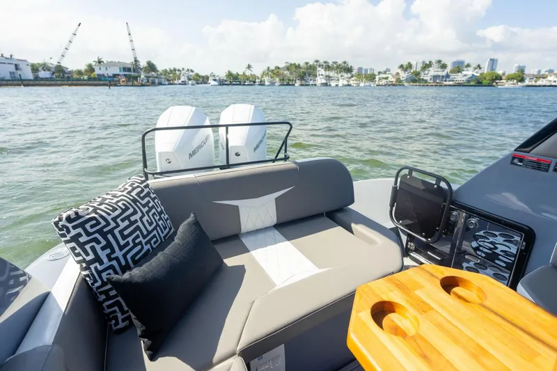  Yacht Photos Pics 2026 Hanover 305 boat interior with cushions, table, and twin Mercury engines on a sunny day.