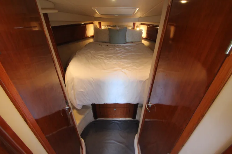  Yacht Photos Pics Cozy bedroom interior of 2004 Sea Ray 40 Sundancer yacht with wooden accents.