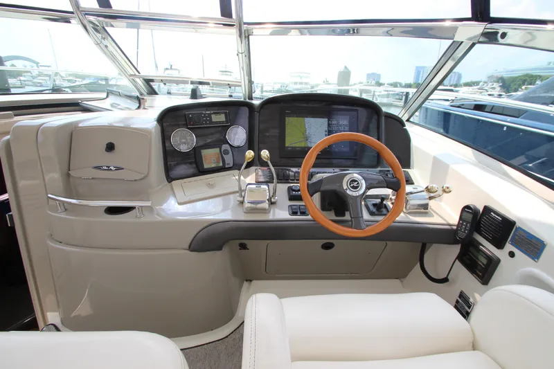  Yacht Photos Pics Helm of 2004 Sea Ray 40 Sundancer with modern navigation equipment and wooden steering wheel.