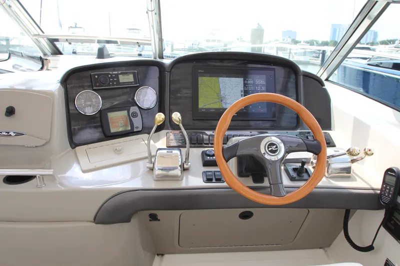  Yacht Photos Pics Helm of 2004 Sea Ray 40 Sundancer with navigation equipment and wooden steering wheel.