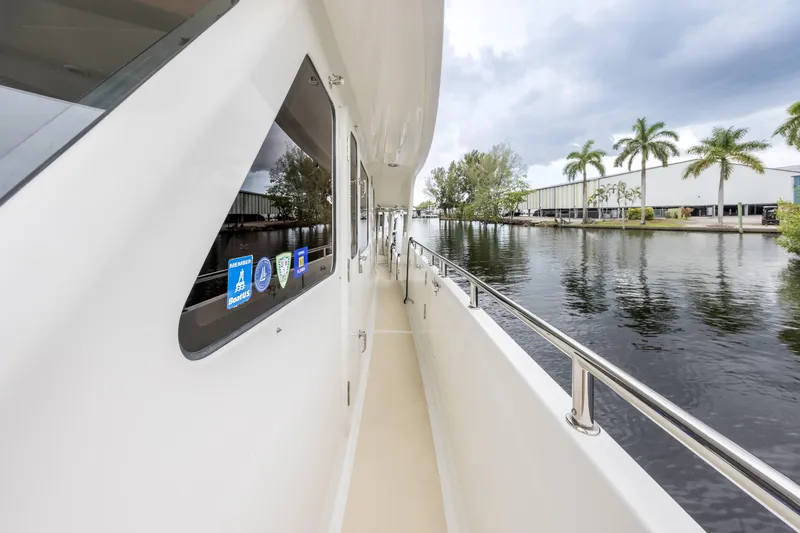 Journey Yacht Photos Pics Side deck view of 2008 Outer Reef Yachts 650 Motoryacht, with waterfront and palm trees.