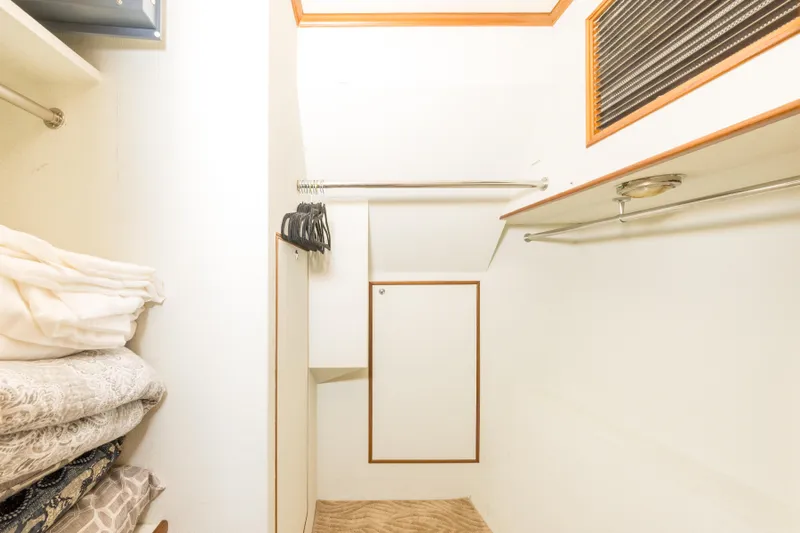 Journey Yacht Photos Pics Walk-in closet on 2008 Outer Reef Yachts 650 Motoryacht with hangers and folded linens.