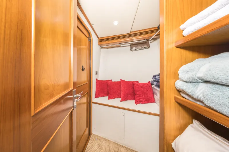 Journey Yacht Photos Pics Cozy cabin interior of 2008 Outer Reef Yachts 650 Motoryacht with red cushions and wooden finish.