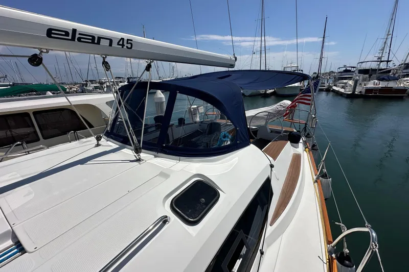 In Stock Now Yacht Photos Pics 2018 Elan 45 Impressions yacht docked in marina, featuring sleek design and blue canopy.