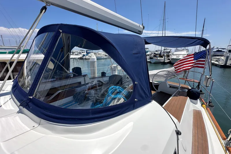 In Stock Now Yacht Photos Pics 2018 Elan 45 Impressions yacht with blue canopy and American flag in marina.