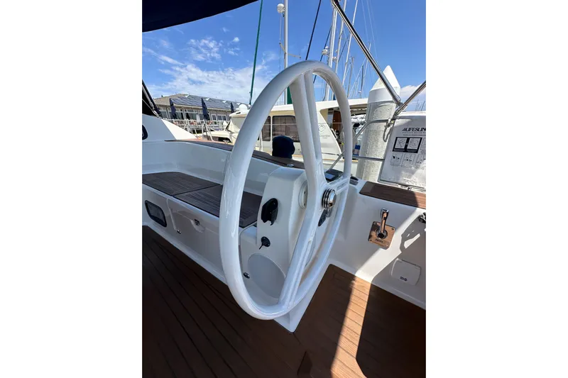 In Stock Now Yacht Photos Pics Steering wheel of 2018 Elan 45 Impressions yacht, docked under clear blue sky.