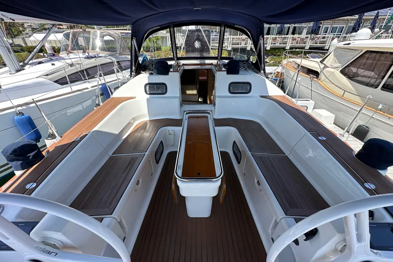 In Stock Now Yacht Photos Pics 2018 Elan 45 Impressions yacht cockpit with wooden seating and steering wheel.