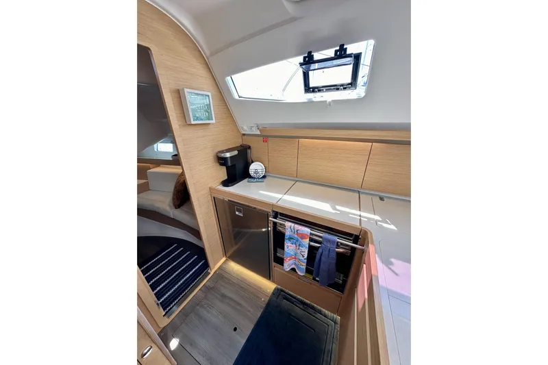 In Stock Now Yacht Photos Pics Modern interior of 2018 Elan 45 Impressions yacht, featuring sleek kitchen and cozy seating area.