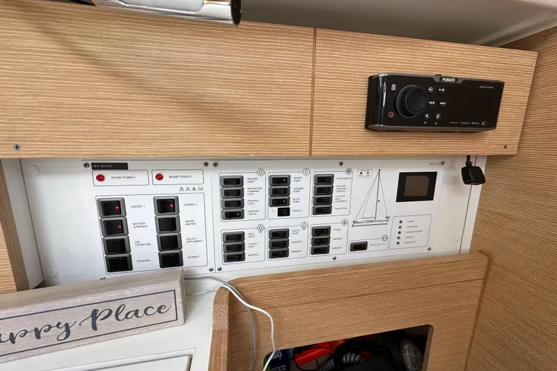 In Stock Now Yacht Photos Pics Control panel of a 2018 Elan 45 Impressions yacht with various switches and a stereo system.