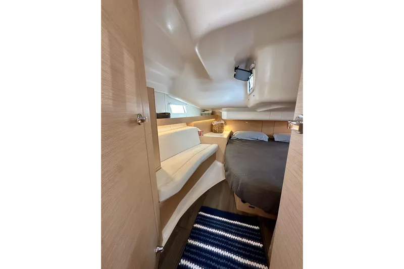 In Stock Now Yacht Photos Pics Interior of 2018 Elan 45 Impressions yacht, featuring cozy cabin with bed and seating.