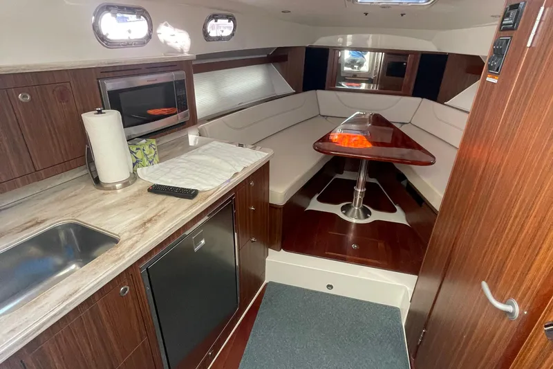  Yacht Photos Pics 2020 Pursuit OS 355 Offshore interior with kitchenette and dining area.