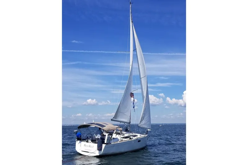  Yacht Photos Pics 2019 Jeanneau Sun Odyssey 349 sailing on open water under clear blue skies.