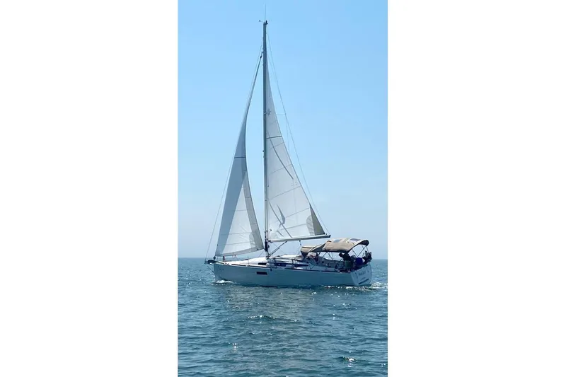  Yacht Photos Pics 2019 Jeanneau Sun Odyssey 349 sailing on open water under clear blue sky.