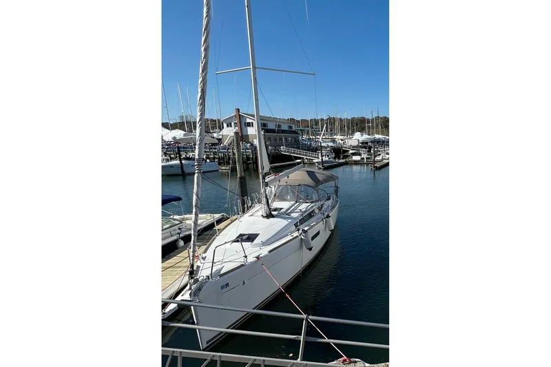  Yacht Photos Pics 2019 Jeanneau Sun Odyssey 349 sailboat docked in a marina under clear blue skies.