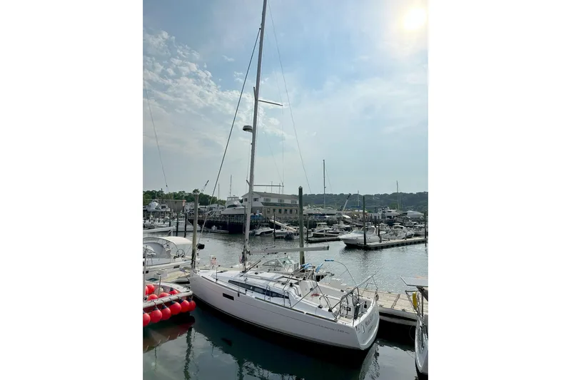  Yacht Photos Pics 2019 Jeanneau Sun Odyssey 349 sailboat docked in a marina under a partly cloudy sky.