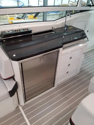  Yacht Photos Pics 2020 Formula 430 Super Sport Crossover boat interior with sleek kitchenette and stainless steel fridge.