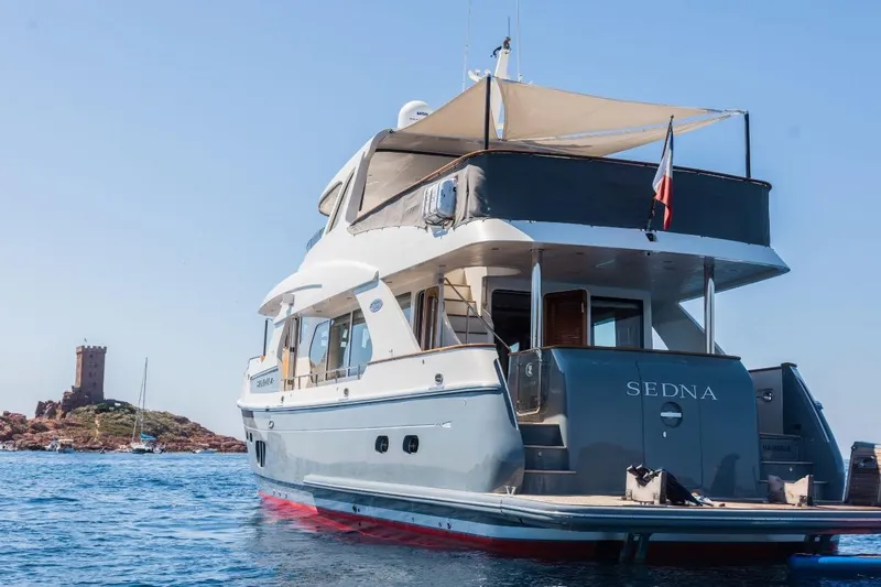 Sedna Yacht Photos Pics Luxury yacht Jet Tern SELENE 72, 2020 model, anchored near a coastal tower.