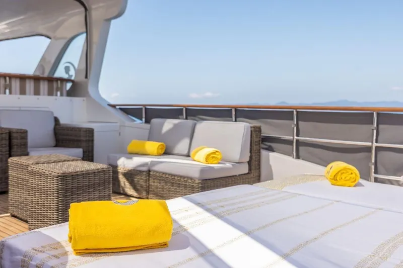 Sedna Yacht Photos Pics Luxurious deck of 2020 Jet Tern SELENE 72 yacht with yellow towels and wicker furniture.