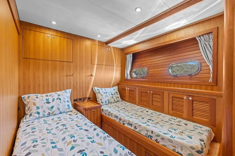 Sedna Yacht Photos Pics Luxurious twin cabin interior on 2020 Jet Tern SELENE 72 yacht, featuring wood paneling and porthole windows.