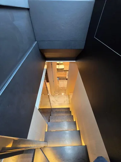 Orca Yacht Photos Pics Staircase inside 2023 Cranchi Sessantasette 67 yacht, featuring modern design and ambient lighting.