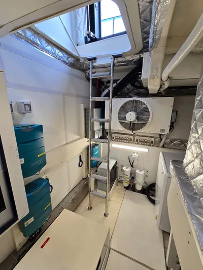 Orca Yacht Photos Pics Engine room of 2023 Cranchi Sessantasette 67 yacht with ladder and equipment.